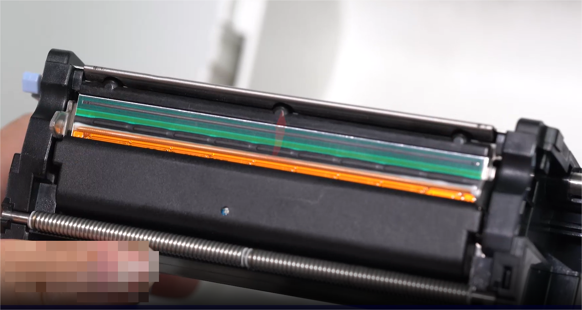 Ett close-up of a person carefully cleaning an electronic component with a swab.